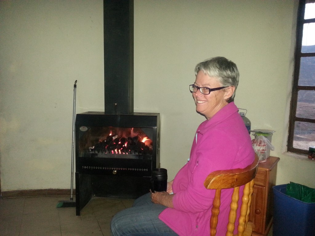 Judy warming in front of the coal fire. Yes it really is coal and the fire was set by a local villager