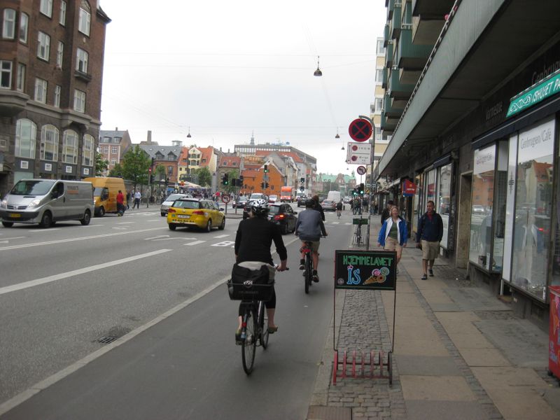A bike lane in Copenhagen. A kerb separates the bike lane from the road.